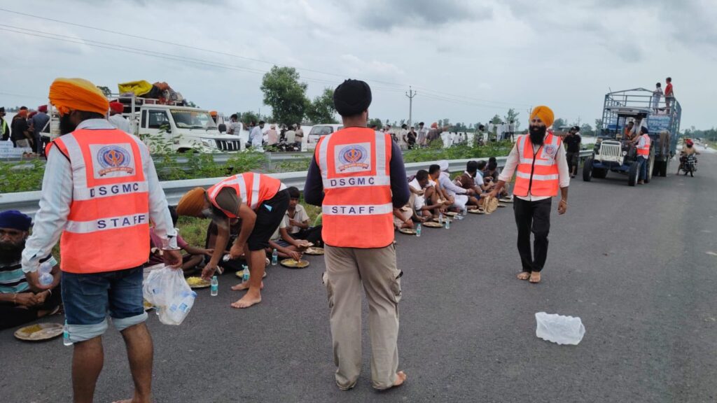 DSGMC volunteers distributing food and relief material to flood-affected families in Punjab.
