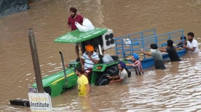 Farmers loading relief material on a tractor to deliver supplies in flood-affected Punjab villages.