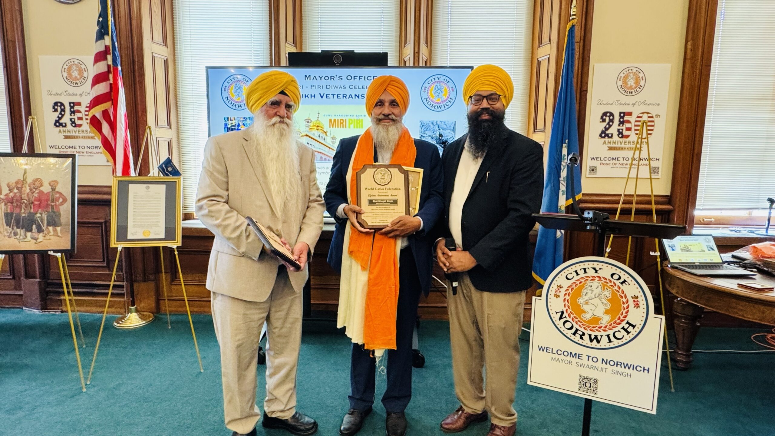 Dr Deep Singh Gen Secretary and S Kalhar honoring S Bhagat Singh Deikwala PA by Lifetime Achievement Award at City Hall Norwich CT