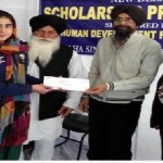 A student is receiving scholarship check from Sikh Human Development Foundation