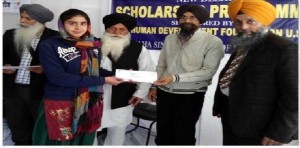A student is receiving scholarship check from Sikh Human Development Foundation A student is receiving scholarship check from Sikh Human Development Foundation