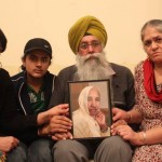 Gurmej Singh and his family holds up a picture of 78-year-old Harbhajan Kaur