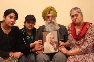 Gurmej Singh and his family holds up a picture of 78-year-old Harbhajan Kaur Gurmej Singh and his family holds up a picture of 78-year-old Harbhajan Kaur