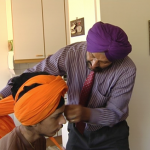 Sukhdarshan Singh Gill (Finland) helps his son to tie his turban